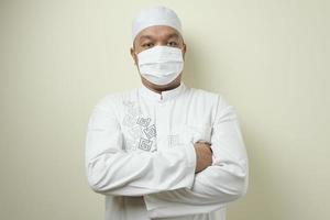 un gros homme musulman asiatique portant un masque pour empêcher la transmission du virus corona photo