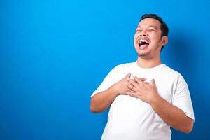 jeune beau garçon asiatique portant une chemise décontractée debout sur un fond rouge isolé souriant et riant fort à haute voix parce que drôle de blague folle avec les mains sur le corps. photo