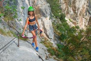 petite fille en via ferratas dans les montagnes photo