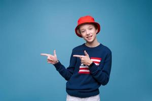 jeune homme souriant et joyeux en chapeau panama rouge et pull bleu avec drapeau américain photo