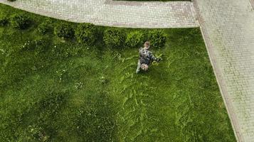 l'homme tondeuse à gazon tond la pelouse la vue d'en haut photo