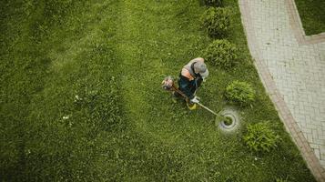 l'homme tondeuse à gazon tond la pelouse la vue d'en haut photo