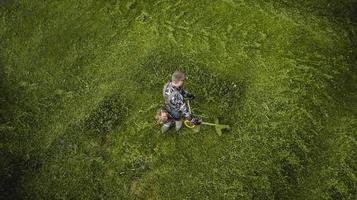 l'homme tondeuse à gazon tond la pelouse la vue d'en haut photo