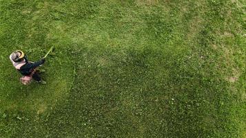 l'homme tondeuse à gazon tond la pelouse la vue d'en haut photo