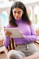 femme persane sur son balcon à l'aide d'une tablette numérique photo