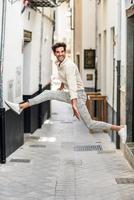 jeune homme heureux sautant dans la rue. photo