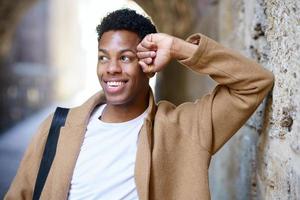 heureux jeune homme noir souriant en milieu urbain. photo