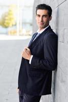 jeune homme d'affaires portant un costume bleu et une cravate en arrière-plan urbain photo