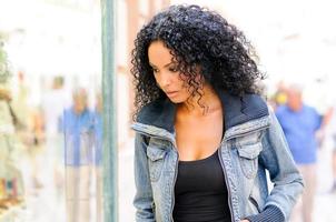 femme noire, coiffure afro, regardant la vitrine photo