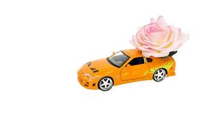 petite voiture avec des roses sur fond blanc photo