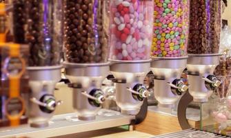 variété colorée de bonbons aux fruits dans des tubes en plastique dans un magasin de bonbons. Jelly Beans en vente dans le magasin. boules de chewing-gum colorées dans une machine à pâtisserie. mise au point sélective. photo