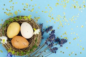 oeufs de pâques faits à la main décorés pour la saison des fêtes sur fond bleu. concept abstrait minimal créatif. photographie de studio photo