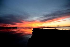 lac et route au coucher du soleil des prairies photo