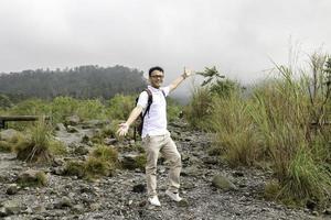 jeune routard asiatique est heureux et aime voyager en montagne photo