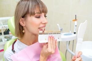 une femme heureuse en dentisterie prend la couleur de l'émail des dents