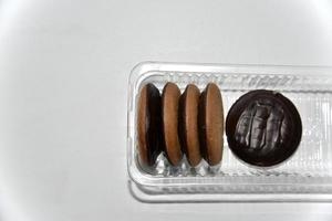 biscuits recouverts de chocolat rond délicieux sur fond blanc photo