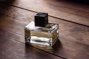 flacon de parfum en verre avec brin de romarin sur podium en bois photo