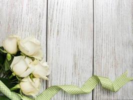 roses blanches sur une table en bois photo