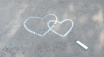 coeur de couple dessiné à la craie sur l'asphalte. confession d'amour. place de la bannière pour le texte, la Saint-Valentin, l'espace de copie de la créativité des enfants, l'été photo