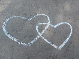 coeur de couple dessiné à la craie sur l'asphalte. confession d'amour. bannière saint valentin, créativité des enfants été photo