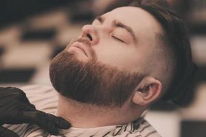 homme avec barbe dans un salon de coiffure. photo