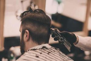 mains dans les gants du coiffeur faisant la coupe de cheveux photo