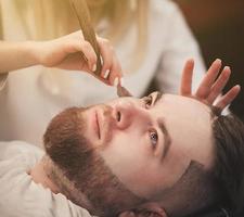homme avec une barbe se rase dans un salon de coiffure photo