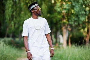 portrait d'un homme afro-américain noir élégant et riche sur des vêtements blancs, des lunettes de soleil et un chapeau photo