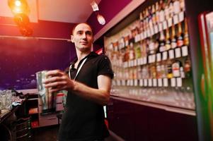 jeune barman jette de la glace au bar photo