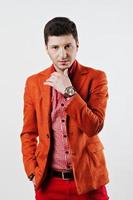 mode jeune homme en costume orange et pantalon rouge pose décontractée au studio photo
