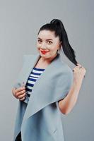 portrait en studio de jeune femme au manteau avec des lèvres rouges photo