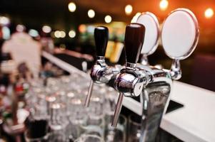 Close up of beer tap lumières de fond au pub photo