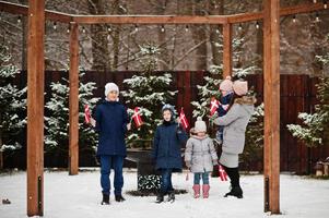 famille avec des drapeaux du danemark en plein air en hiver. voyage dans les pays scandinaves. les danois les plus heureux. photo