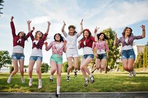 sept filles heureuses et sexy en short court sautant et s'amusant au parc lors d'une soirée entre célibataires photo