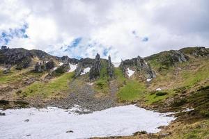 vue sur la pente couverte de neige gelée de la colline contre la falaise rocheuse photo