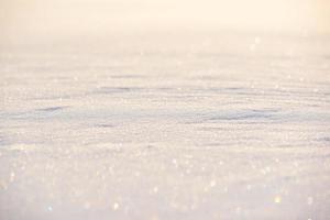 texture de neige blanche étincelante au soleil. le premier plan et l'arrière-plan sont flous. photo