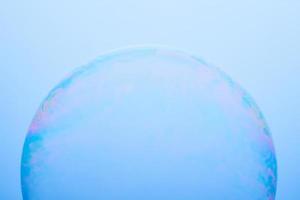 une bulle de savon isolée sur fond bleu. photographie abstraite. photo