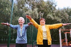 deux femmes matures faisant des exercices sportifs dans le parc. concept de mode de vie sain photo