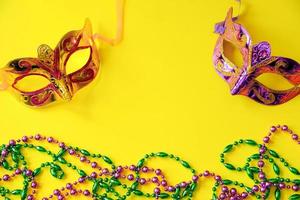 deux masques de carnaval multicolores et perles sur fond jaune. mardi Gras photo