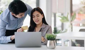 jeune couple détenant une carte de crédit et utilisant le téléphone. achats en ligne, commerce électronique, services bancaires par Internet, dépenser de l'argent. photo