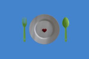 assiette avec coeur rouge et couverts sur fond en bois, mise à plat. photo