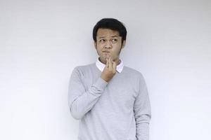 un jeune homme asiatique porte une chemise grise avec un geste d'idée pensant et regardant photo