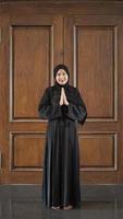 femme en robe musulmane noire gesticulant désolé dans la mosquée photo