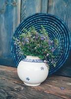 fleurs de champ bleu dans un vase sur fond de bois photo