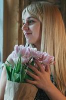 femme blonde floue avec un bouquet de fleurs près de la fenêtre photo