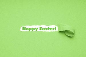 Joyeuses pâques salutation sur fond de papier vert déchiré photo