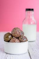 collation saine. boule d'énergie avec prune de date, sésame noir et blanc, chia et rasin dans un bol en céramique sur une table en bois. végétalien végétarien. photo