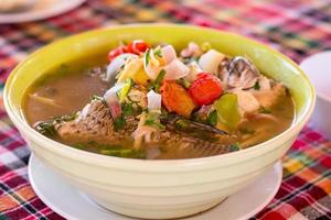 soupe de poisson aigre-douce épicée thaïlandaise dans un bol blanc. en thaï appelez tom yum. délicieuse cuisine thaïlandaise. photo