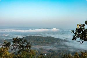 mer de brouillard couvre la zone au sommet de la colline doi phu thok, chiang khan, loei, thaïlande avec fond de lever de soleil en hiver. photo