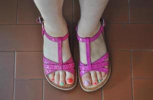 pieds de fille avec des sandales sur un trottoir photo